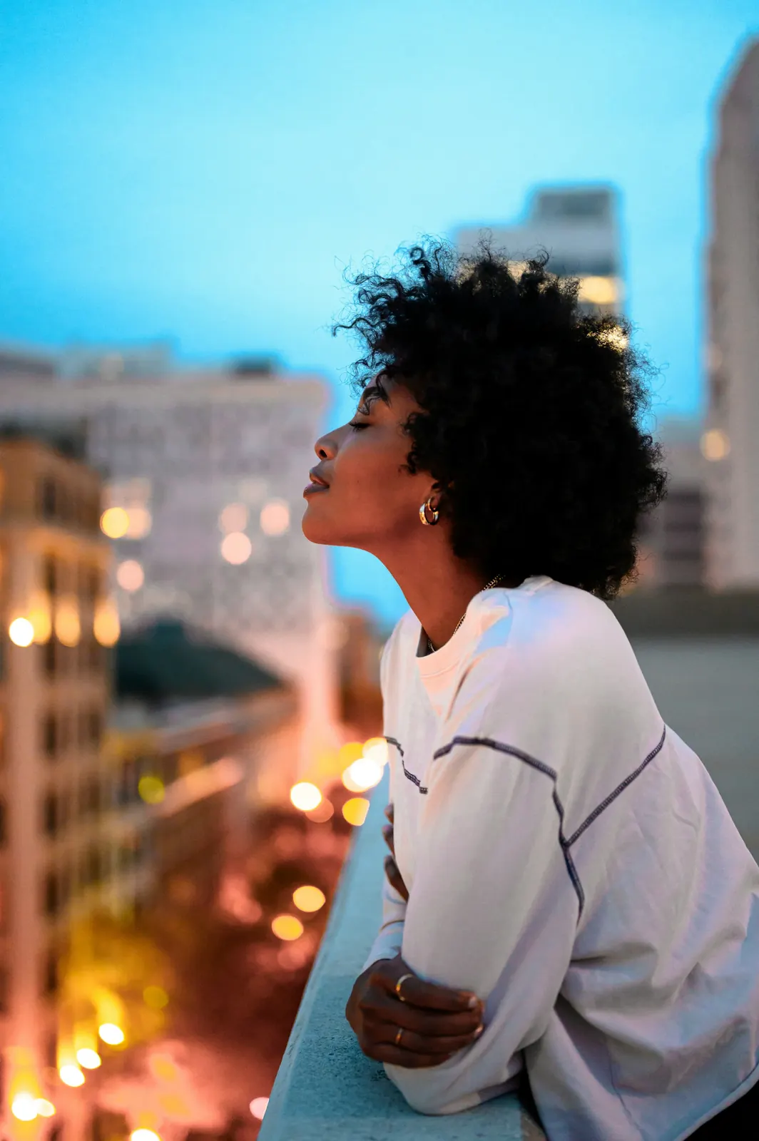 Melanated woman embracing nature, representing sacred feminine energy and holistic wellness